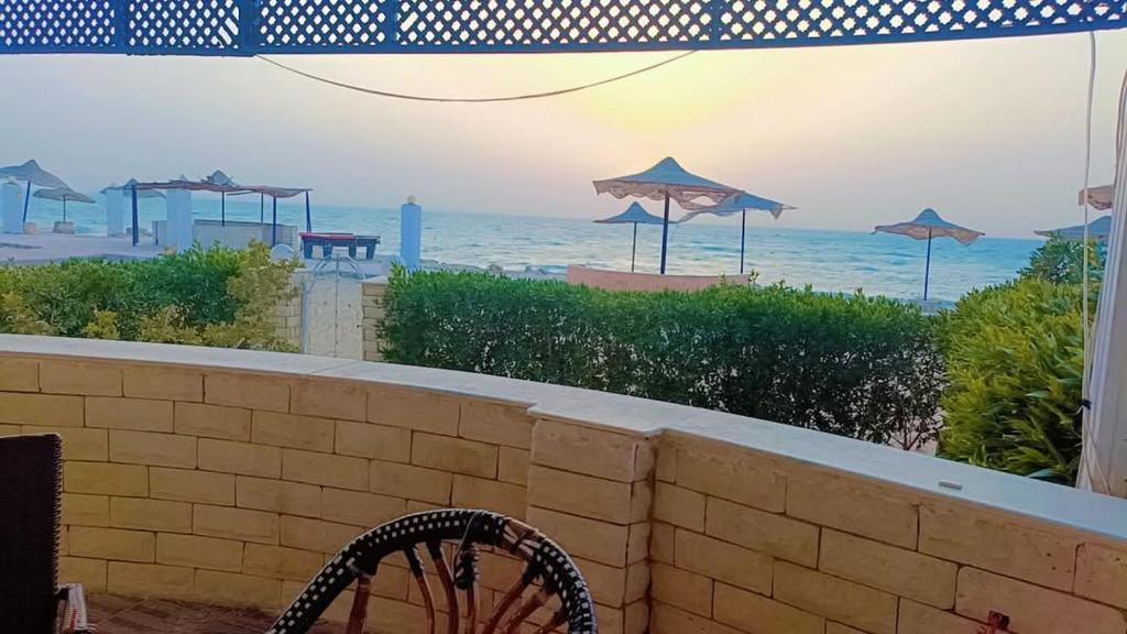 a view of a beach with umbrellas and the ocean at شاليه راكان الاستجمام صف أول على البحر in Ras Sedr