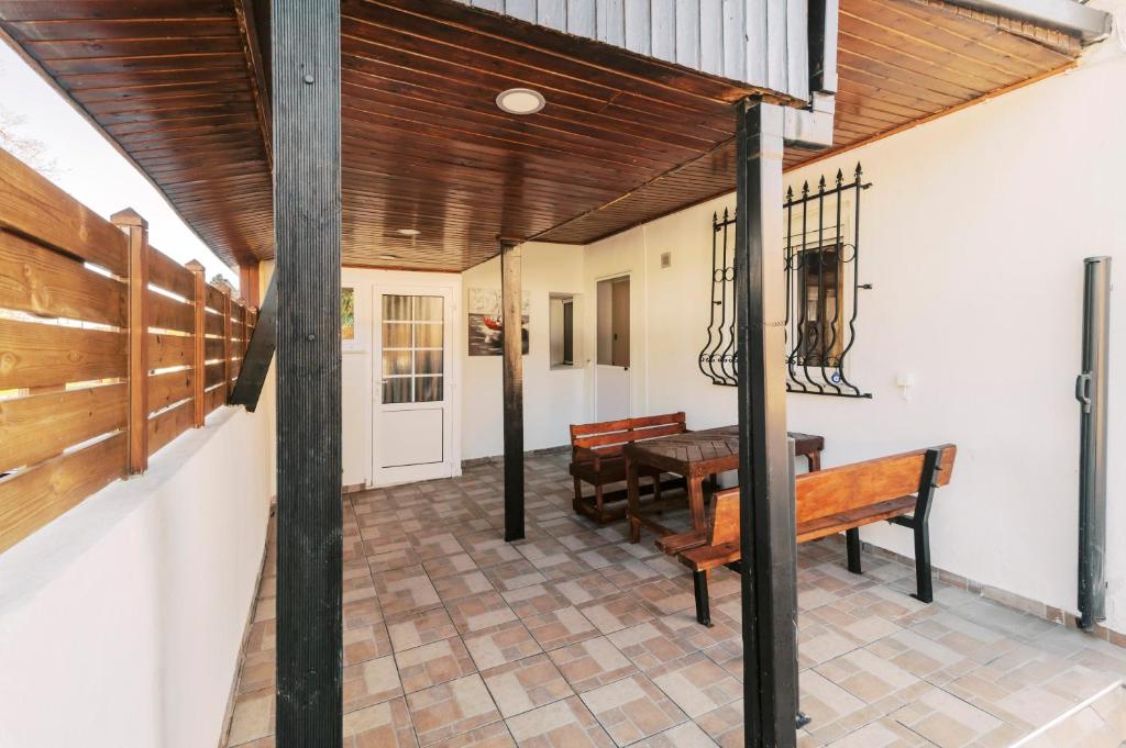 a porch with a bench and a table at Louis House in Rhodes Town
