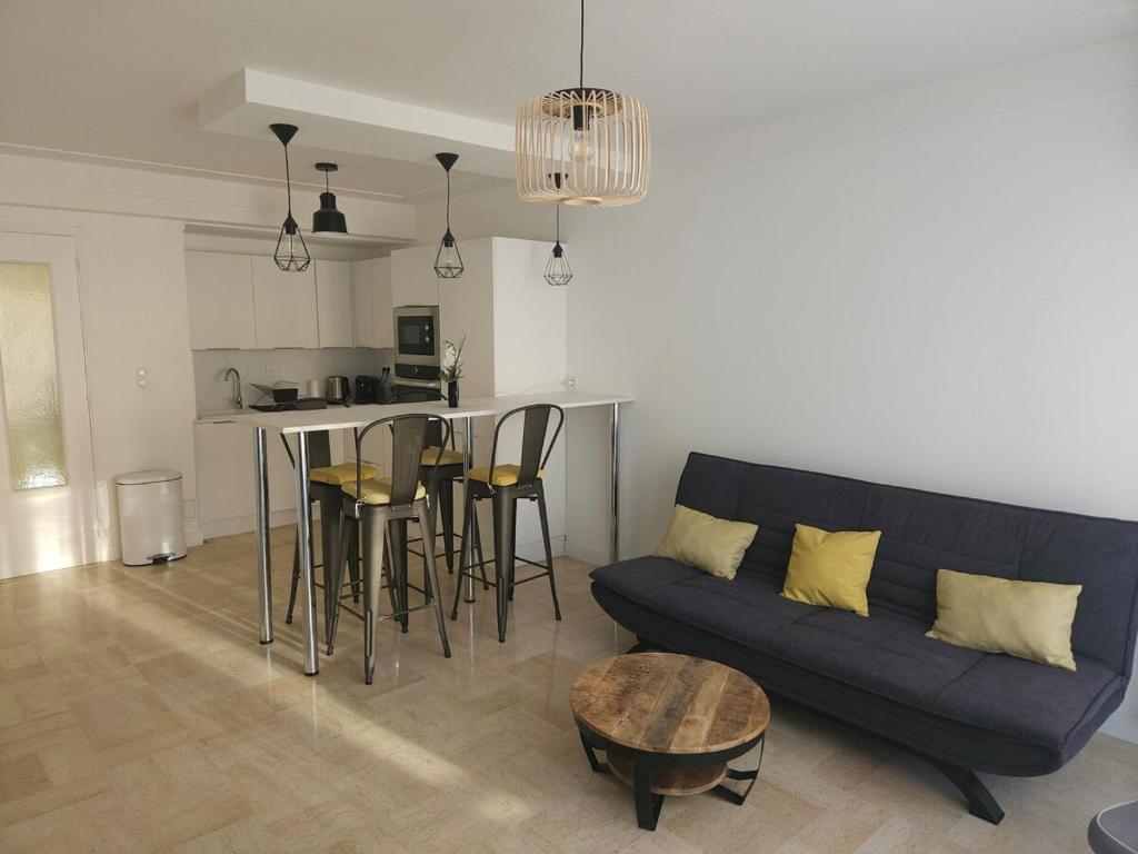 un salon avec un canapé et une table dans l'établissement Centre Antibes Le Piadon 3 pièces neuf Parking, à Antibes