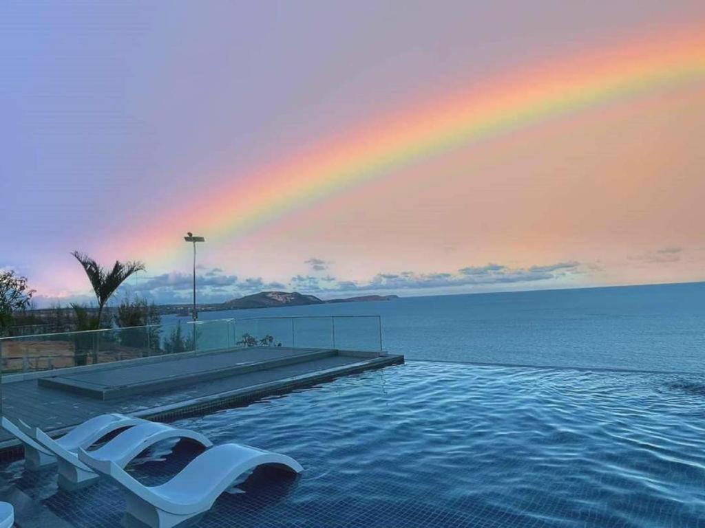 a pool with a rainbow in the sky and a lounge chair at APEC-NGÔI NHÀ CỦA BẠN và TÔI in Ấp Thiẹn Ái
