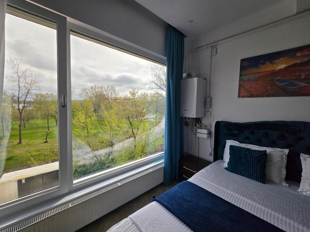 een slaapkamer met een bed en een groot raam bij Sky Studio in Constanţa