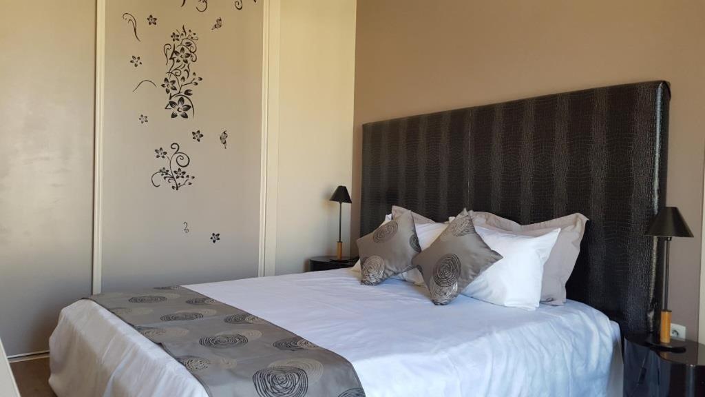 une chambre avec un grand lit avec des draps et des oreillers blancs dans l'établissement Nice Centre, Magnifique Studio Proche Mer, à Nice