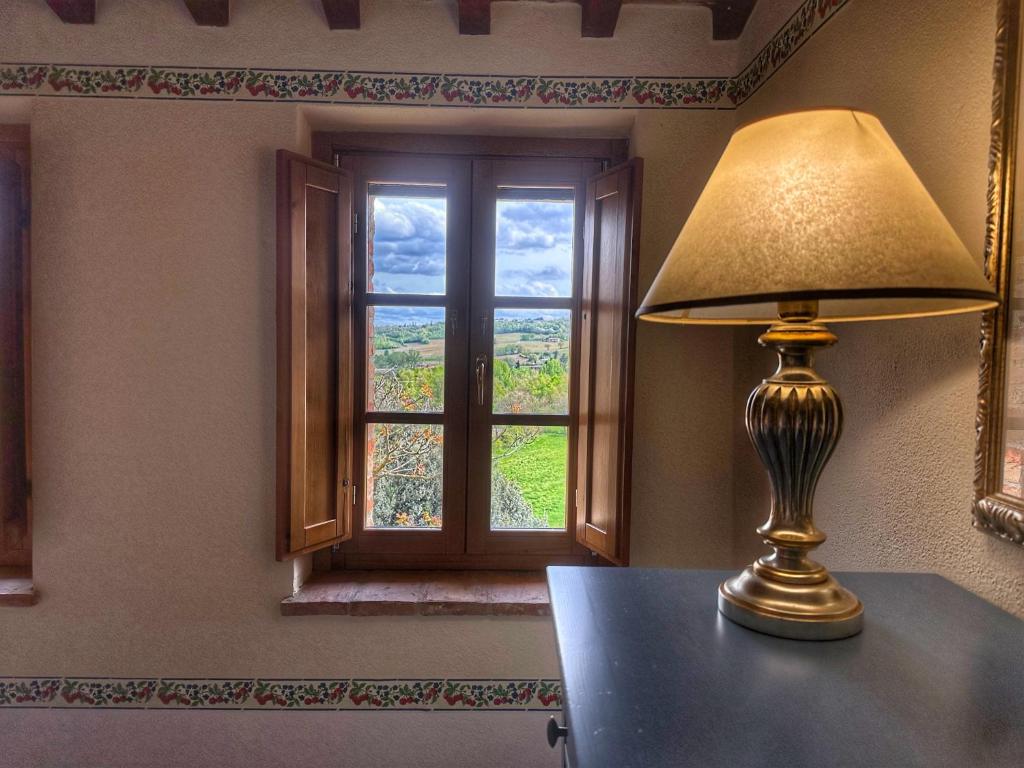 una lámpara sentada en una mesa frente a una ventana en Agriturismo Borgo 7 Tigli - APT 2, en Montepulciano