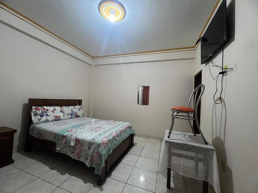 Residencial 9 de Septiembre في سانتا كروز دي لا سيرا: غرفة نوم مع سرير وتلفزيون بشاشة مسطحة