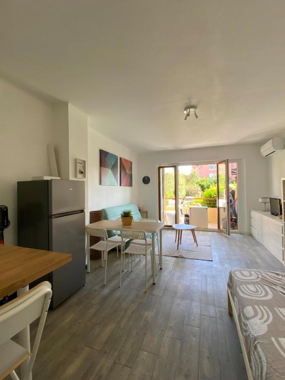 Il dispose d'une cuisine et d'un salon avec une table et un réfrigérateur. dans l'établissement Studio centre ville parking privé Clim et wifi, à Saint-Raphaël