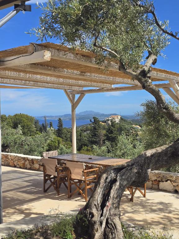 a table and benches under a wooden pergola at Lagom Retreat - ASKOS in Agios Nikolaos