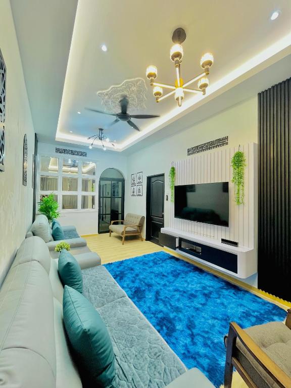 ein Wohnzimmer mit einem großen blauen Teppich in der Unterkunft Homestay Deedora 87 in Seri Manjung