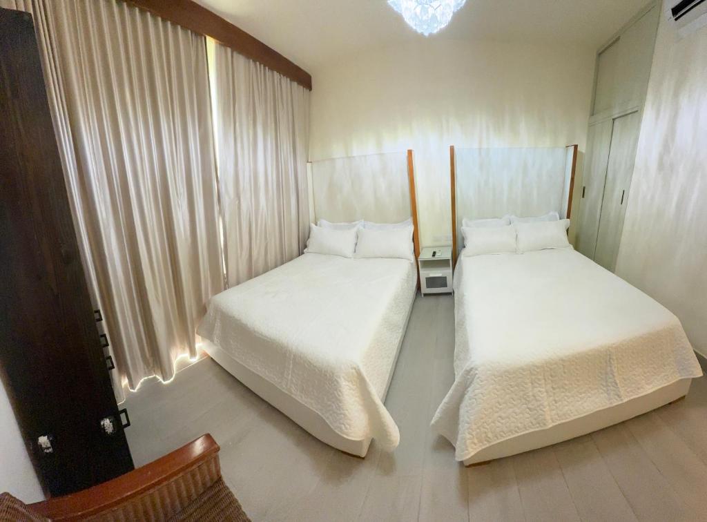 two beds in a small room with a window at Maris Luxe Vibe Residence Dominicus in La Laguna