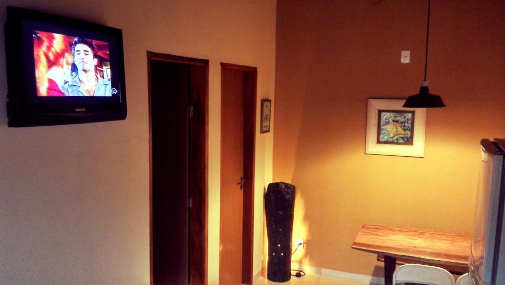 a television on the wall of a room with a table at CASA BONITA in Bonito