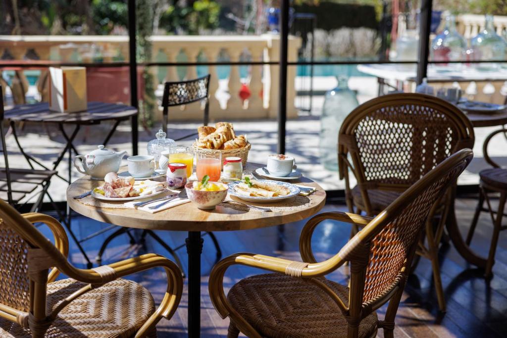 a table with food and drinks on a patio at Hôtel La Villa Sainte Valérie Adults Only in Juan-les-Pins