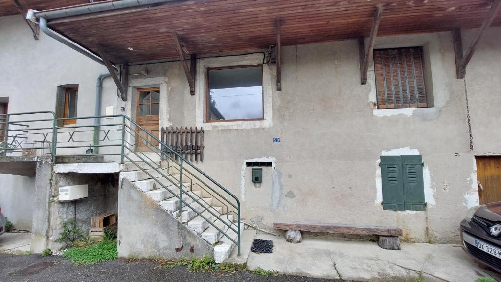 an old house with a staircase and a window at Maison de village in Corbonod