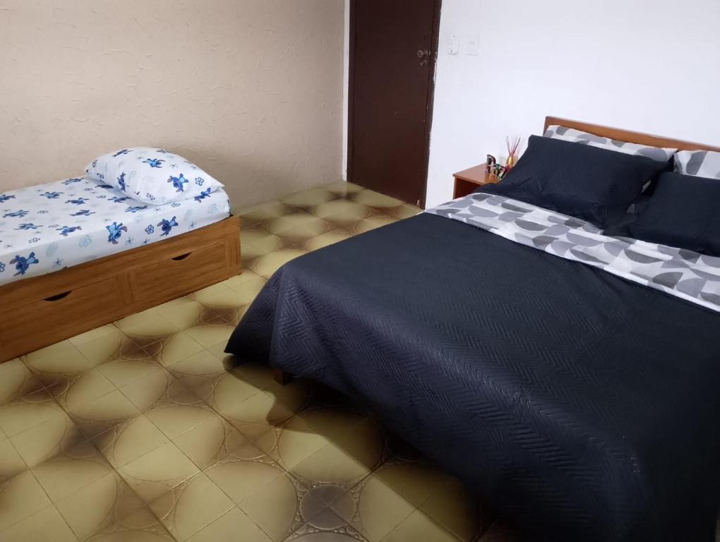 een slaapkamer met een bed met een blauw dekbed bij Apartamento Arara Azul in Cabo Frio
