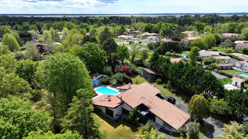 - une vue aérienne sur une maison avec une piscine et des arbres dans l'établissement Villa Entre lac, forêt, océan, à Biscarrosse