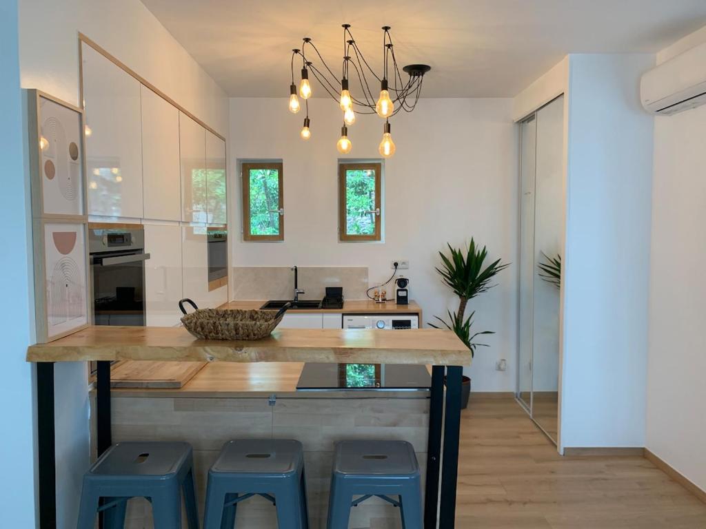 - une cuisine avec une grande île dotée de tabourets bleus dans l'établissement Appt Place Gramont, à Pau