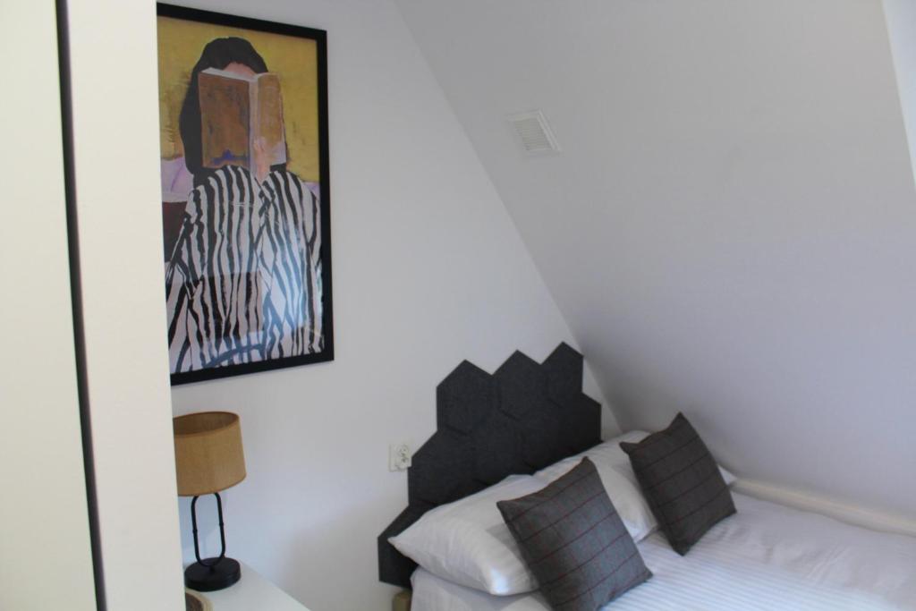 a bedroom with a bed and a painting on the wall at Mini AP Apartment's in Wałbrzych