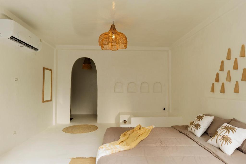 a bedroom with a bed and a chandelier at The Hidden Home in Patong Beach