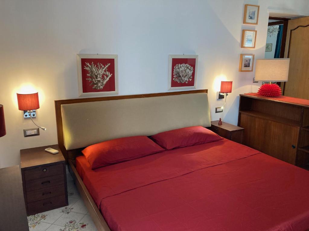 a bedroom with a large red bed with red pillows at Casa Anna Capri Charme in Capri