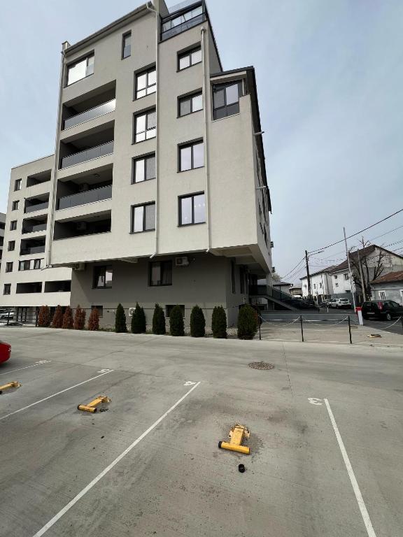 a parking lot in front of a large building at Garsoniera Zona Stadion in Craiova