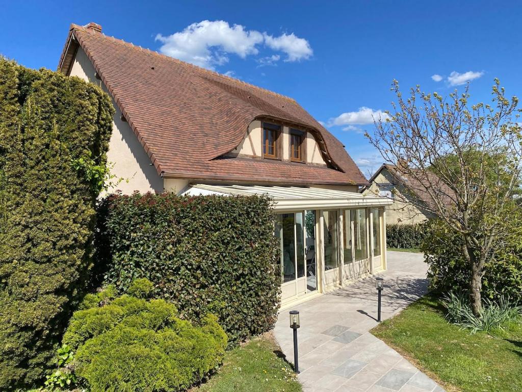 a house with a brown roof and some bushes at Ma belle Normande entre terre et mer - My beautiful Normandy, between land and sea in Saint-Léonard