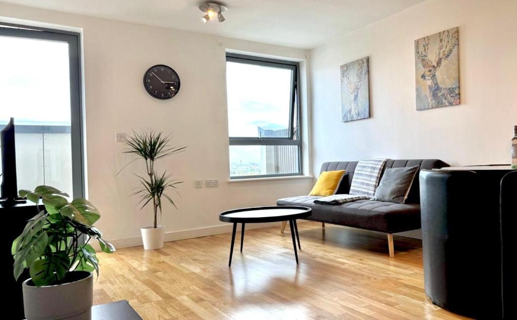 a living room with a couch and a table at Stylish 2-Bed Flat with Parking in London