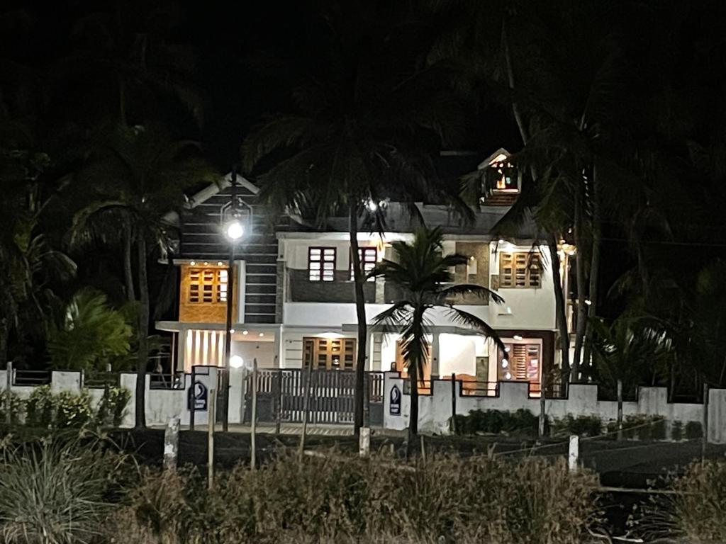 CheruvattūrにあるThe Kayal Delightのヤシの木が目の前に広がる白い家