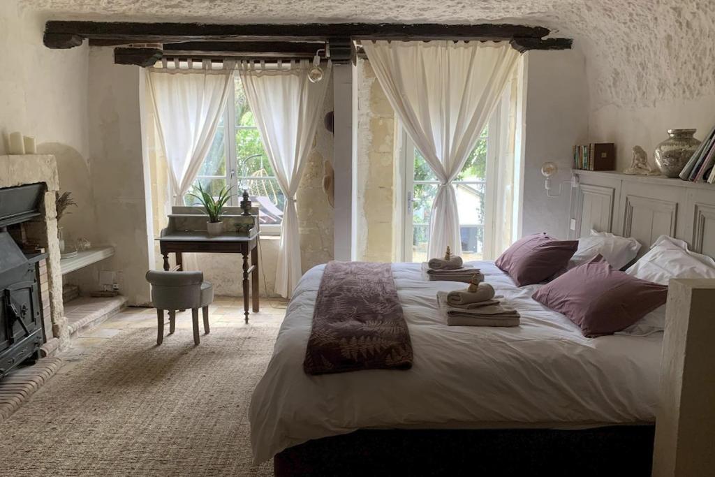 une chambre avec un grand lit et un piano dans l'établissement Charming troglodyte near Amboise, à Pocé-sur-Cisse