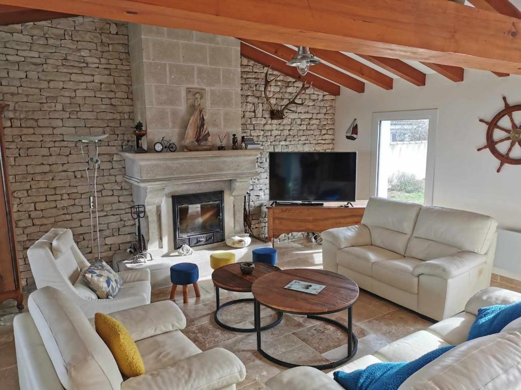 Elle comprend un salon doté d'un mobilier blanc et d'une cheminée. dans l'établissement Sea-facing villa in La Flotte-en-Ré, à La Flotte