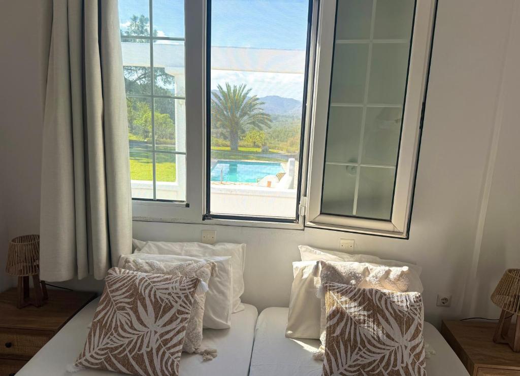 a bedroom with a large window and a bed with pillows at Villa Paradisos Archangelos in Archangelos