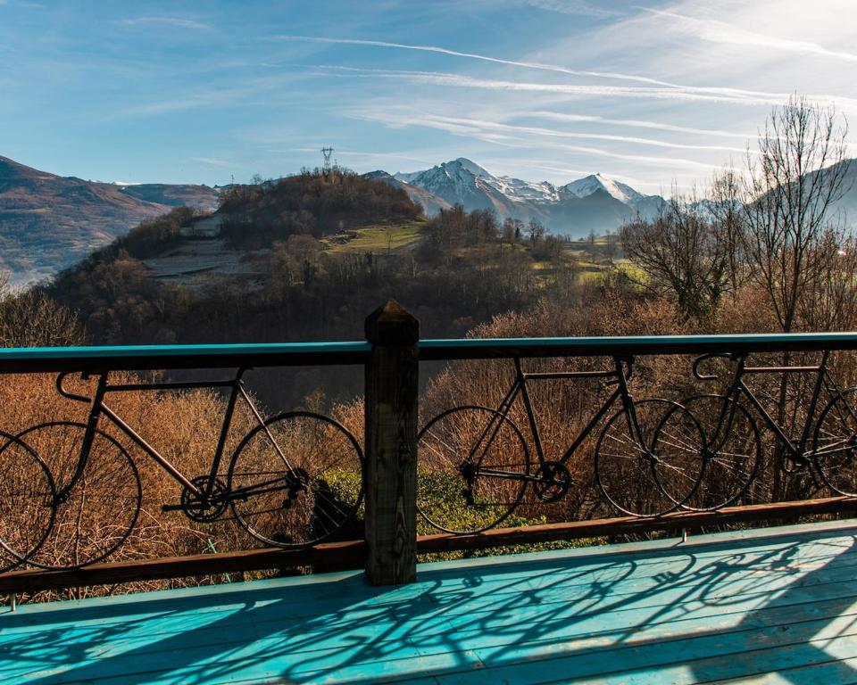un vélo garé sur un rail à côté d'une montagne dans l'établissement Terrafirma 40m2 Flat with Private 20m2 Terrace on D918 Ideal for Cyclists, à Arras-en-Lavedan