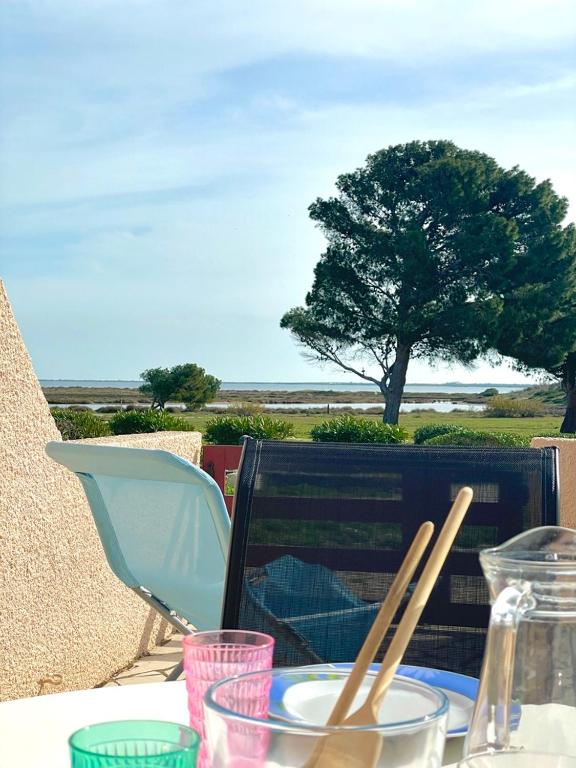 une table avec une plaque de nourriture et des baguettes dans l'établissement Maison - piscine - clim - wifi - vue lac - 4 pers, à Fitou