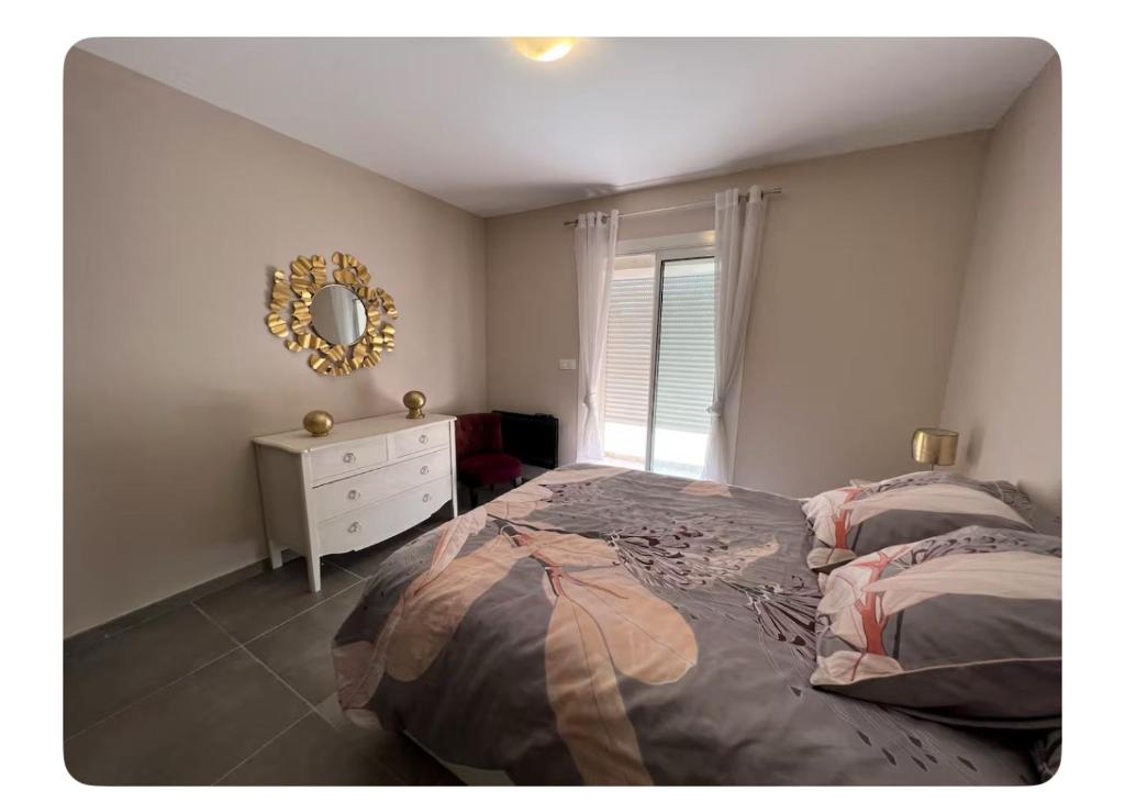 - une chambre avec un lit, un miroir et une commode dans l'établissement Petit havre du Brusc de 80 M2, à Six-Fours-les-Plages