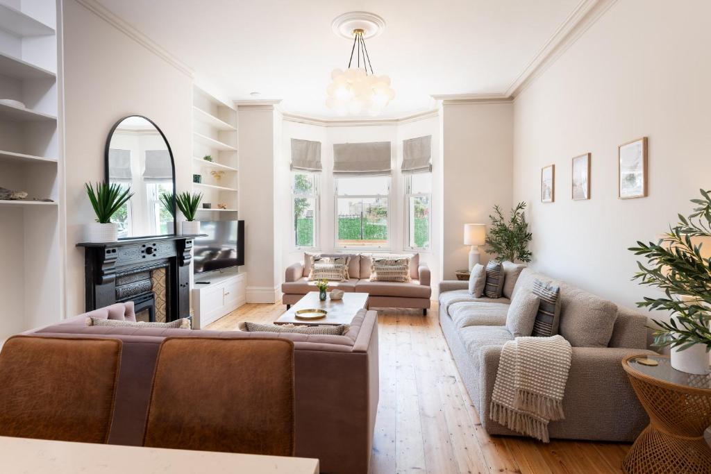 a living room with a couch and a fireplace at Stunning Townhouse by the sea, Hot Tub sleeps 17 in Seaton