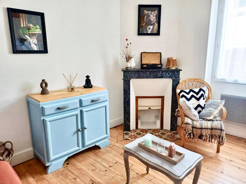 un salon avec une armoire bleue et une cheminée dans l'établissement Appartement de charme centre ville Langeac, à Langeac