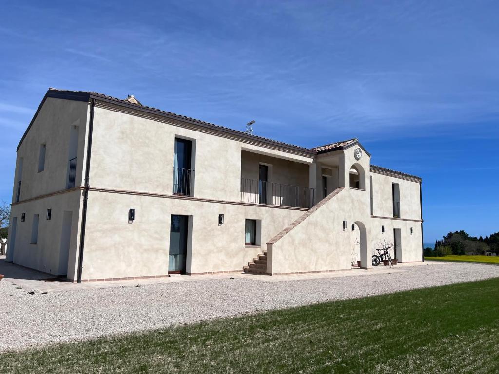 een groot wit gebouw op een grasveld bij La Collina sul Mare in Porto SantʼElpidio
