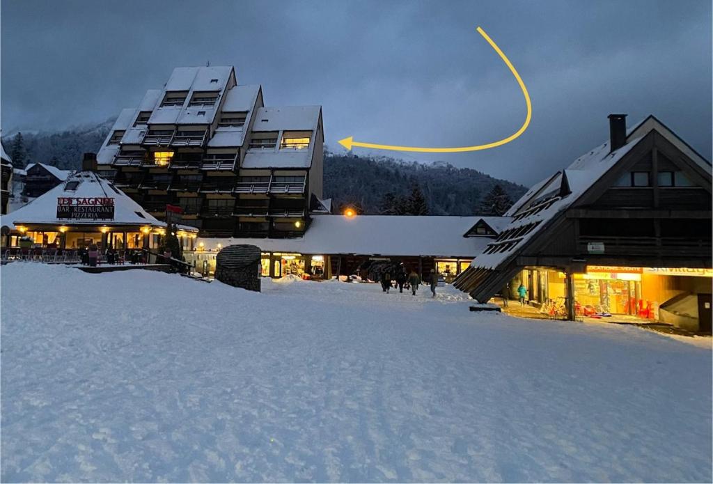 a large building in the snow with snow covered ground at Super Lioran T2 dernier étage in Laveissière