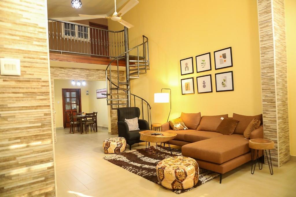 a living room with a couch and a staircase at Huberta Haven in Accra