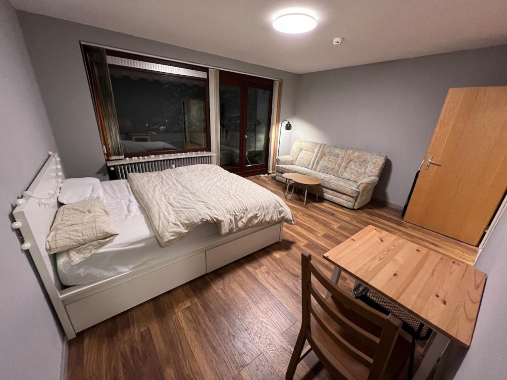 a bedroom with a bed and a chair and a table at Renovated apartment with Wi-Fi in Walkenried