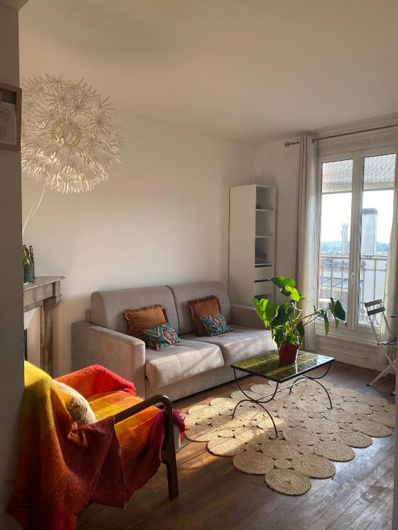 un salon avec un canapé et une table dans l'établissement Centre ville du Perreux near to Paris & Disneyland, à Le Perreux-Sur-Marne