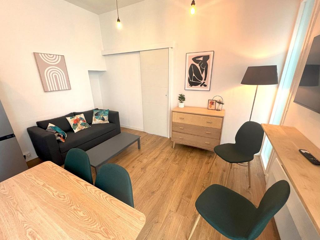 un salon avec un canapé, une table et des chaises dans l'établissement LAMENNAIS GAUCHE - T3 rénové en plein centre rennais, à Rennes