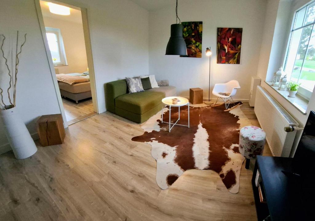a living room with a cow rug on the floor at 30 qm Fewo ländliche Lage Nossen in Nossen