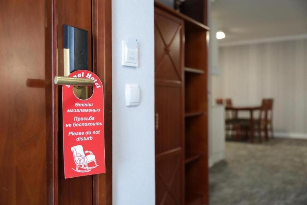 a red sign on the door of a room at SAMAL Hotel in Aksay