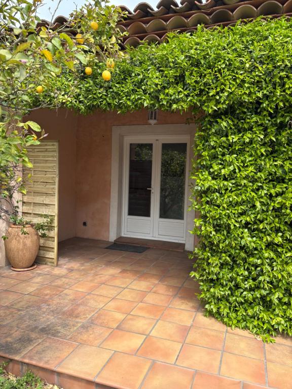 une entrée à une maison avec une haie orange dans l'établissement Studio tout confort, à La Crau