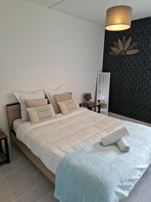 une chambre avec un grand lit blanc dans une pièce dans l'établissement Gîte la Broceliande, à Blois