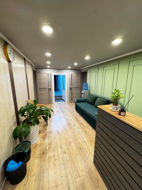 a living room with a blue couch and some plants at Hostel Navi Osh in Osh