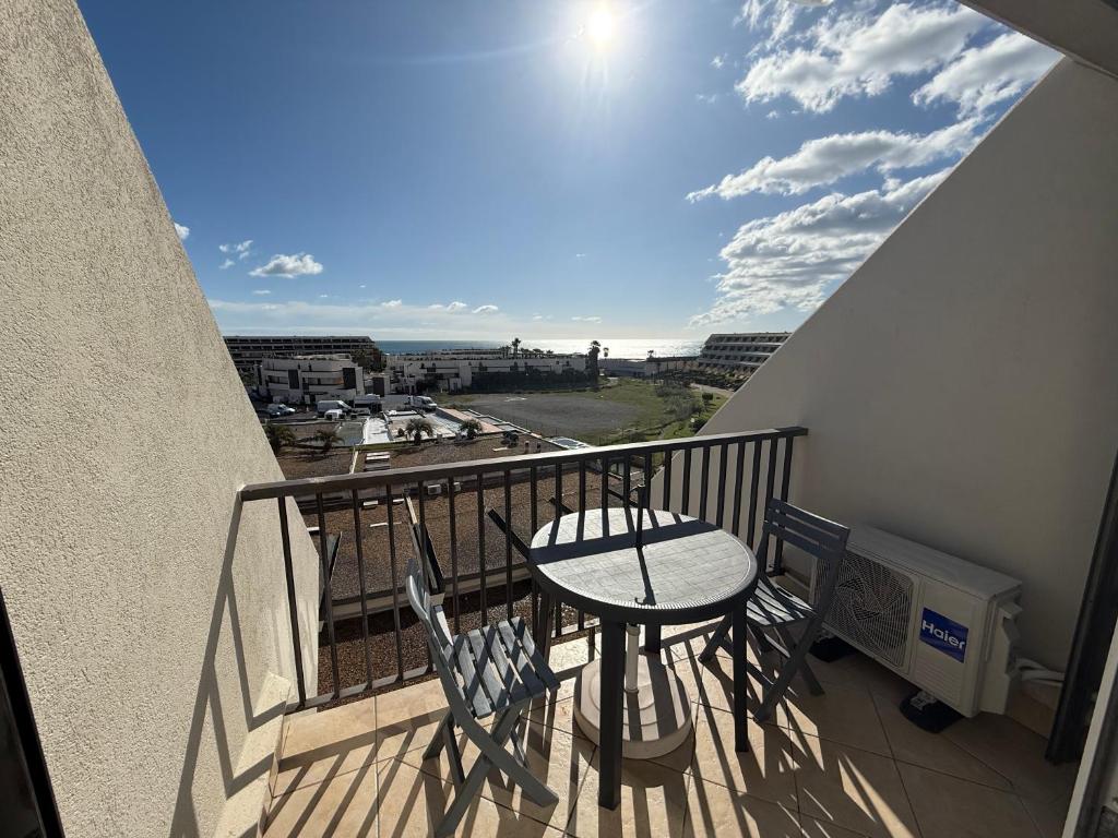 un balcon avec une table et des chaises sur un balcon dans l'établissement Studio Naturiste WILD Heliopolis F 96, au Cap d'Agde