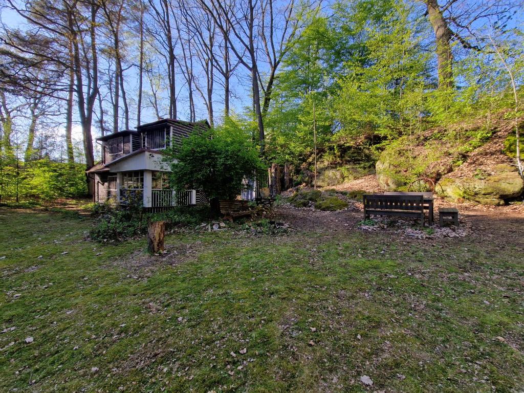 une maison au milieu d'un champ avec un banc dans l'établissement Chata Libošovice 109, à Libošovice