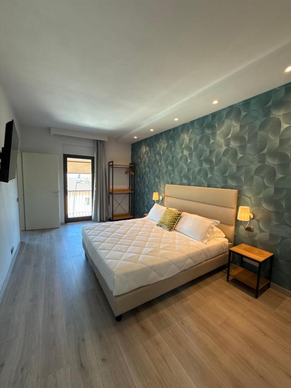 a bedroom with a large bed and a stone wall at ApartHotel Del Corso in Castiglione della Pescaia