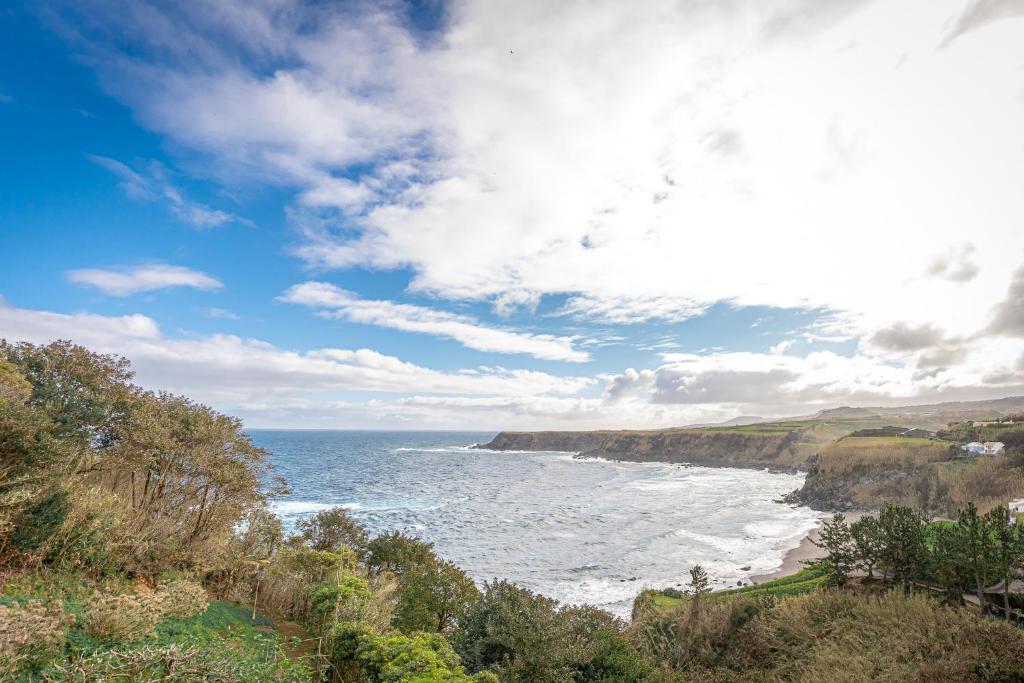 Blick auf einen Strand mit Meer und Wolken in der Unterkunft Eagle's Perch in Porto Formoso in Porto Formoso