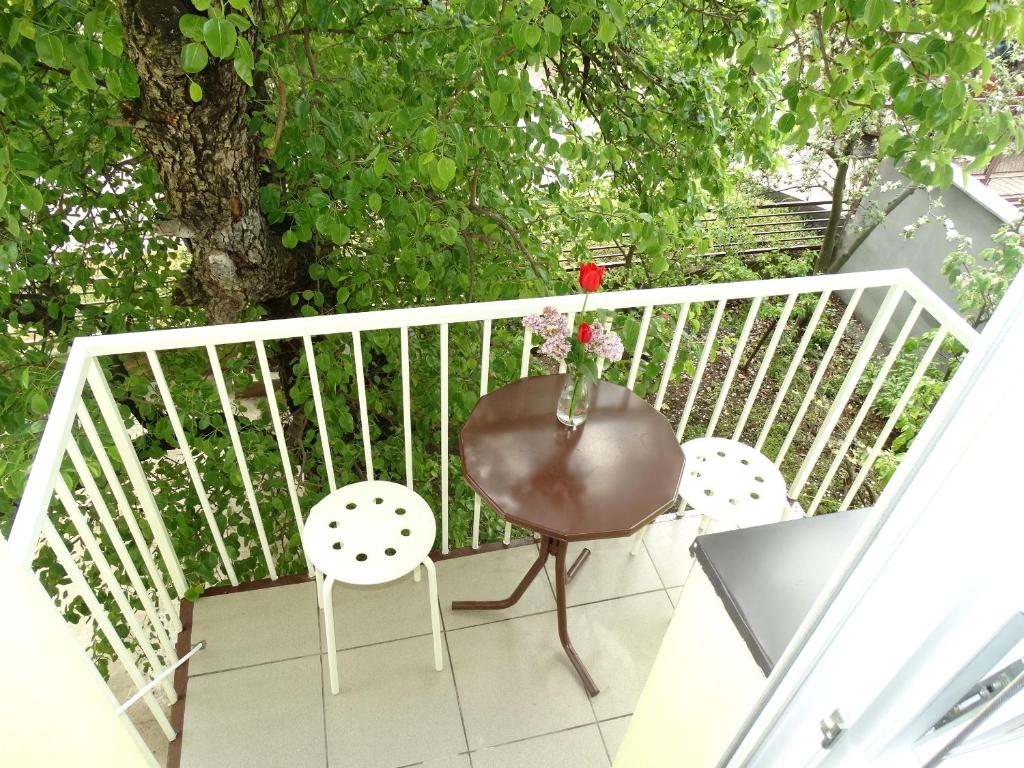 a balcony with a table and two chairs and a laptop at Vila Jenic in Soko Banja