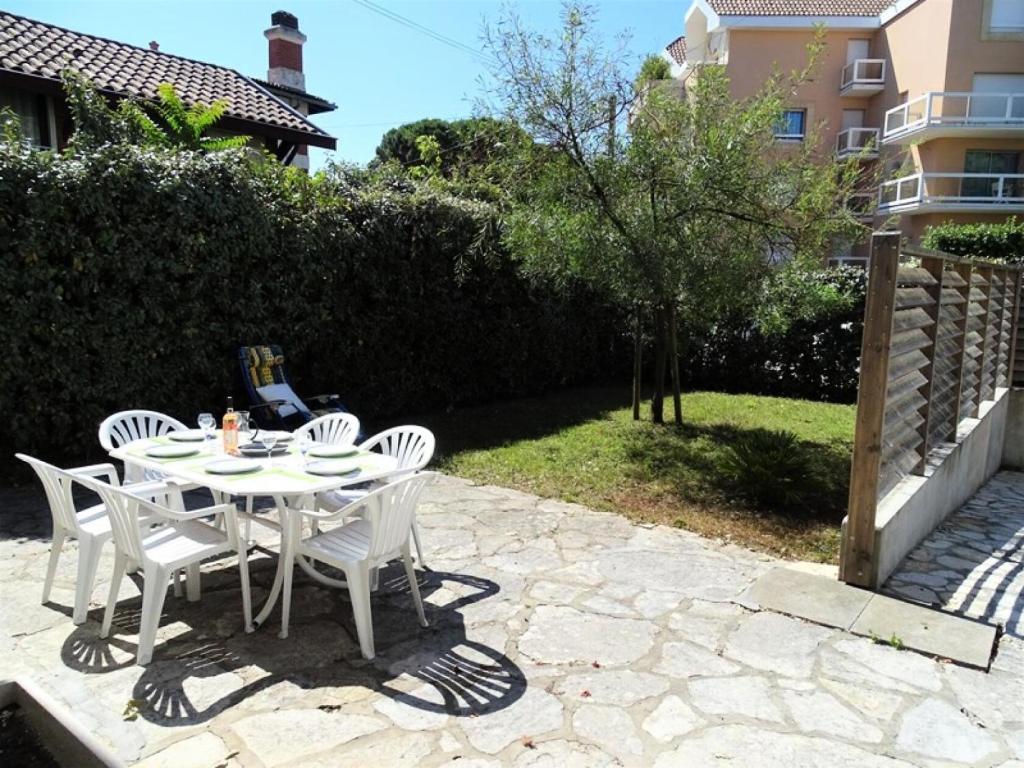 une table blanche et des chaises sur une terrasse dans l'établissement Résidence 408-arcachon - Arcachon centre - Quartier Casino MAE-9584, à Arcachon